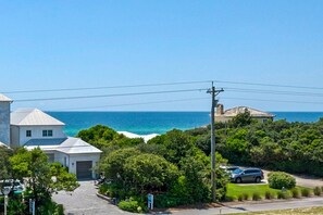 A coastal residential area with houses, a paved road, and a view of the ocean. - 🌊Seabreeze 30A | Beach Across Street | Bikes | Community Pool (Inlet Beach)