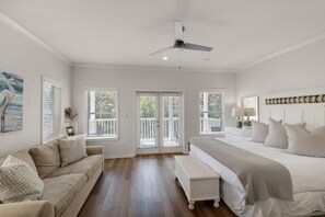 A bedroom with a bed, a bench, a ceiling fan, and a painting. - 🌊Seabreeze 30A | Beach Across Street | Bikes | Community Pool (Inlet Beach)