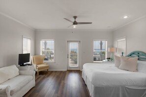 A bedroom with a bed, a chair, a television, and a ceiling fan. - 🌊Seabreeze 30A | Beach Across Street | Bikes | Community Pool (Inlet Beach)