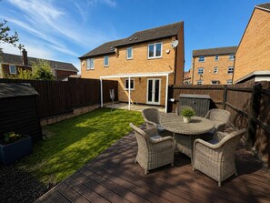 A backyard with a wooden deck, outdoor furniture, and a lawn. - Arnold 3-bed House, Sleeps 5 With Garden & Parking (Nottingham)