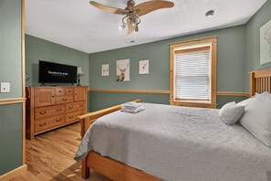 A bedroom with a bed, a wooden dresser, a television, and artwork on the wall. - Ski-Out to Hatley Pointe | Hot Tub | Sleeps 8 (Mars Hill)
