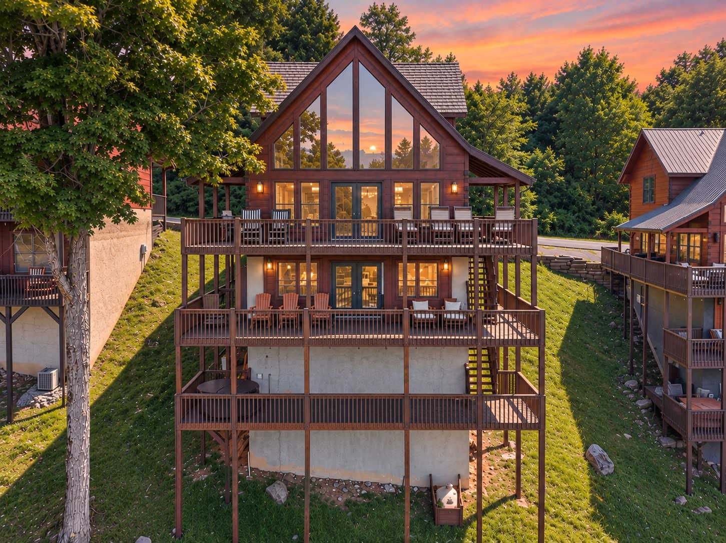 Eine mehrstöckige Holzhütte mit Balkonen, großen Fenstern und Blick auf den umliegenden Wald.