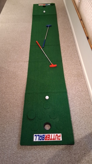 A shuffleboard table with two pucks and two tongs.