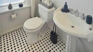 A bathroom with a toilet, sink, and window. - Sunlit One Bedroom In Allentown (Buffalo)