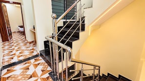 A staircase with metal railings and a geometric patterned floor.