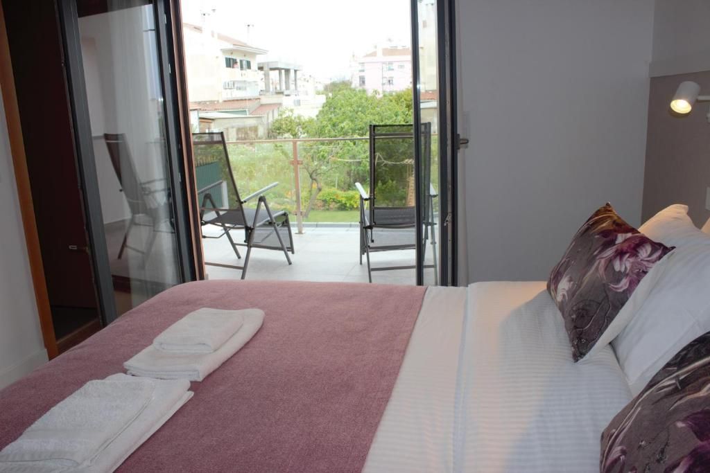Une chambre d’hôtel avec un lit, un balcon avec une chaise et une vue sur l’extérieur.