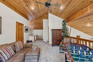 A cozy living room with a brown leather sofa, a foosball table, and a wooden ceiling. - Keystone Ranch Escape | Hot Tub + Grill + Deck (Dillon)