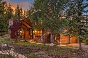 A stone cabin with a wooden porch, a chimney, and a garage. - Keystone Ranch Escape | Hot Tub + Grill + Deck (Dillon)