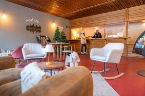 Un interior acogedor con techo de madera, una recepción y zonas de estar.