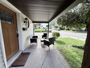 A covered porch with outdoor furniture, a door, and a mailbox. - Delightful Quiet 3 BR 2 bath home in Carnegie (Carnegie)