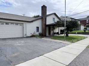 A residential house with a garage, a chimney, and a front yard with a sidewalk and a tree. - Delightful Quiet 3 BR 2 bath home in Carnegie (Carnegie)