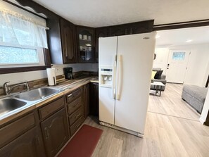 A compact kitchen with a refrigerator, double sink, and wooden cabinets. - Delightful Quiet 3 BR 2 bath home in Carnegie (Carnegie)