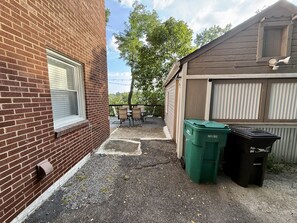 A brick building with a window, a garage door, and two trash bins. - Quiet & near downtown Carnegie (Carnegie)