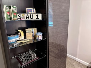 A shelf with various items including a chessboard, a toy figure, and some boxes. - Quiet & near downtown Carnegie (Carnegie)