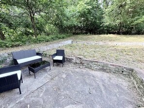 An outdoor seating area with wicker furniture and a concrete floor. - Private clean McKees Rocks 2 King bed House (Pittsburgh)