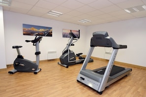 Ett gym med tre motionscyklar och ett löpband.