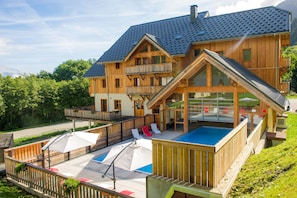 A wooden chalet with a swimming pool, outdoor seating, and a balcony. - Proche des pistes | Piscine & Sauna sur place (Saint-Colomban-des-Villards)