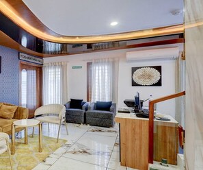 Uma sala de estar moderna com um sofá, cadeiras, uma mesa de escritório e uma área de recepção.