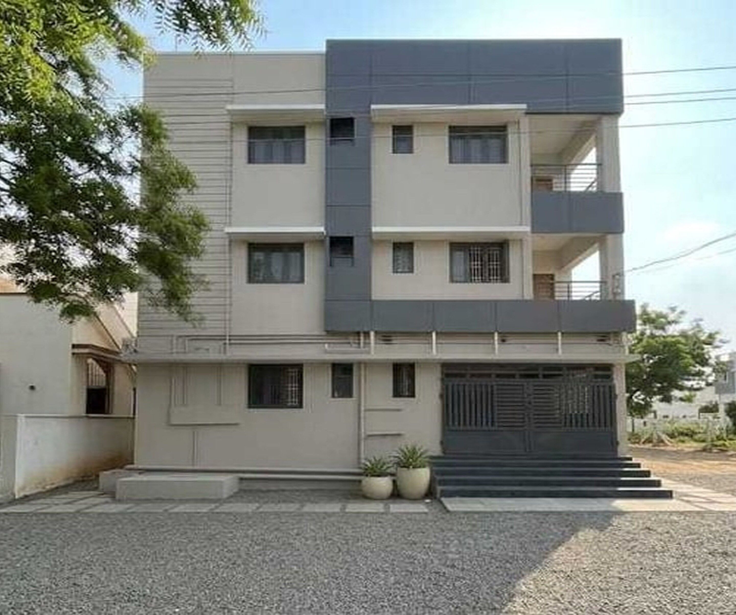 A modern multi-story building with a flat facade, multiple windows, and a gated entrance.