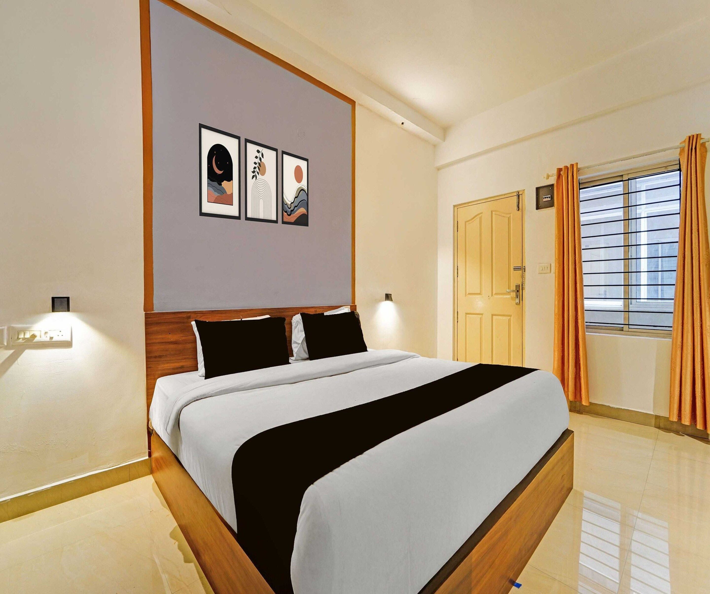 Quarto de hotel com cama, luminária na parede, porta e janela com cortinas.