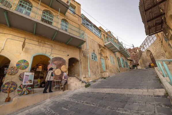 A street with buildings, a staircase, and a shop with colorful items.