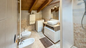 Un bagno con il water, il lavandino e la doccia.