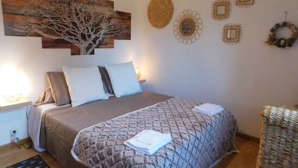 Ein Schlafzimmer mit einem Bett, einem Nachttisch, einer Wandlampe und Wanddekoration.