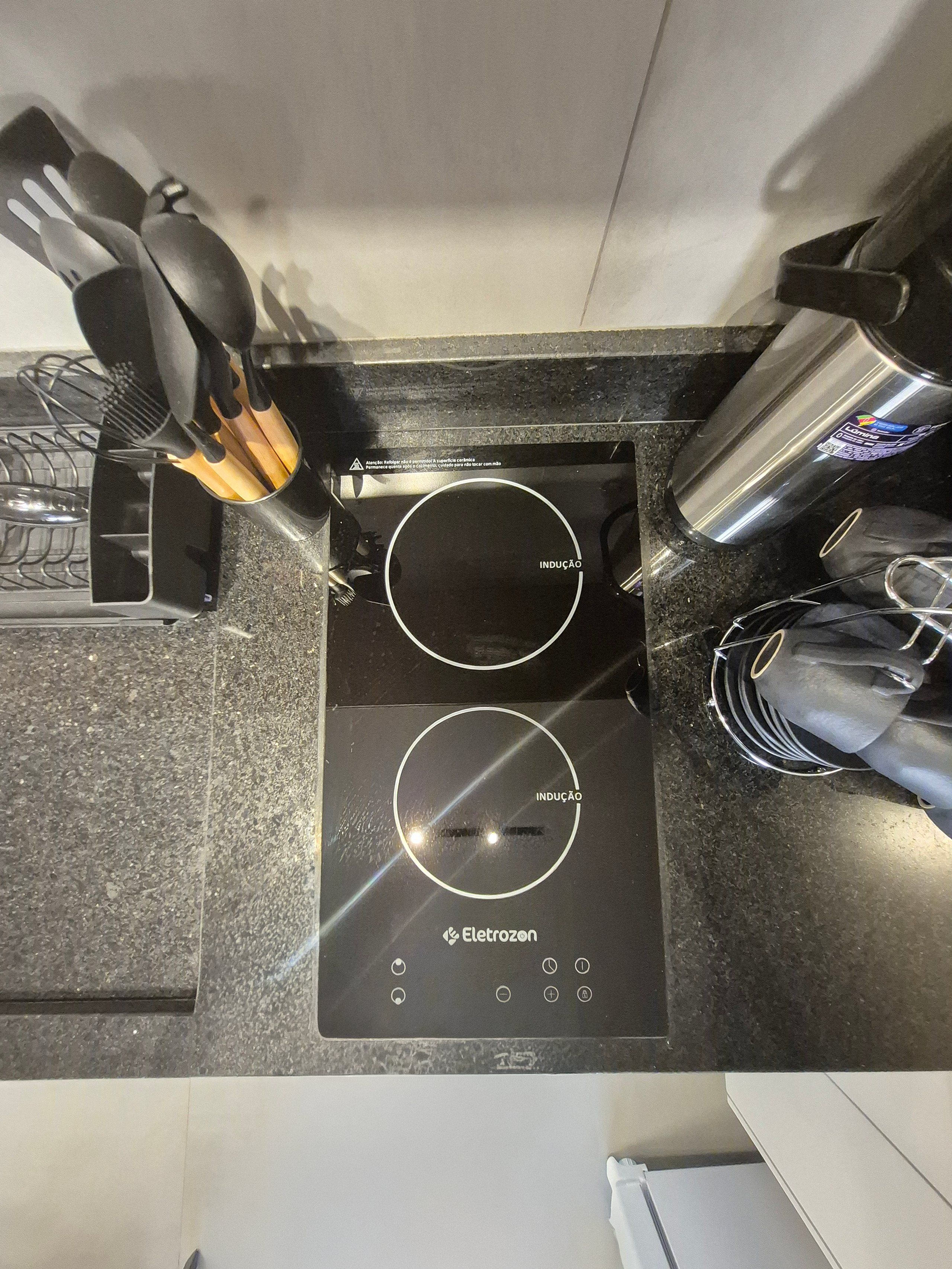 A black induction cooktop with two circular induction zones and a control panel with various buttons.