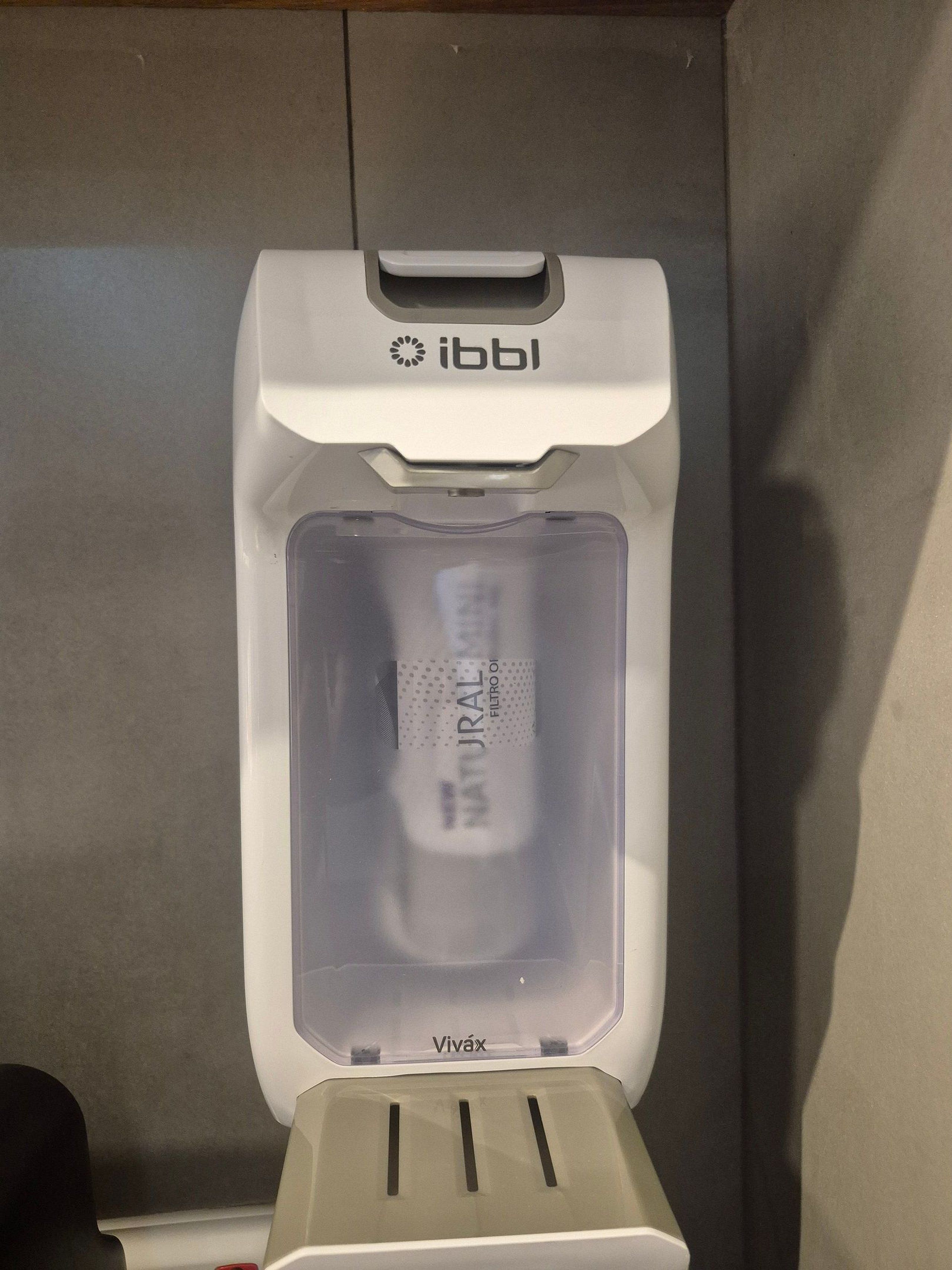 A water dispenser with a transparent bottle of water labeled 'NATURAL FILTER OI' and the brand 'Vivax' on a white surface.