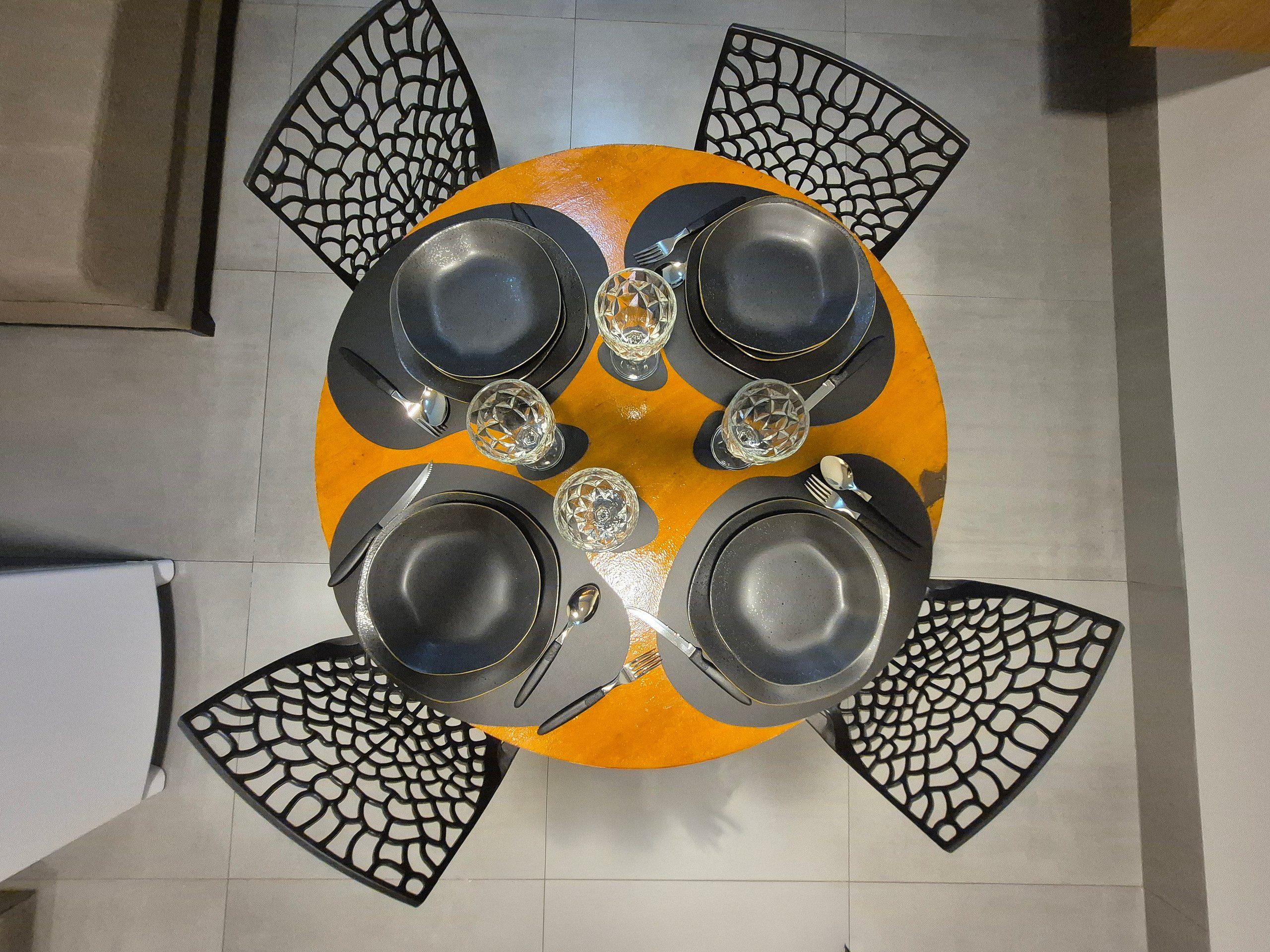 A round table with black chairs, each with a unique cut-out design.