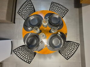 Una mesa redonda con sillas negras, cada una con un diseño recortado único.