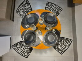 Mesa redonda com cadeiras pretas, cada uma com um design recortado exclusivo.