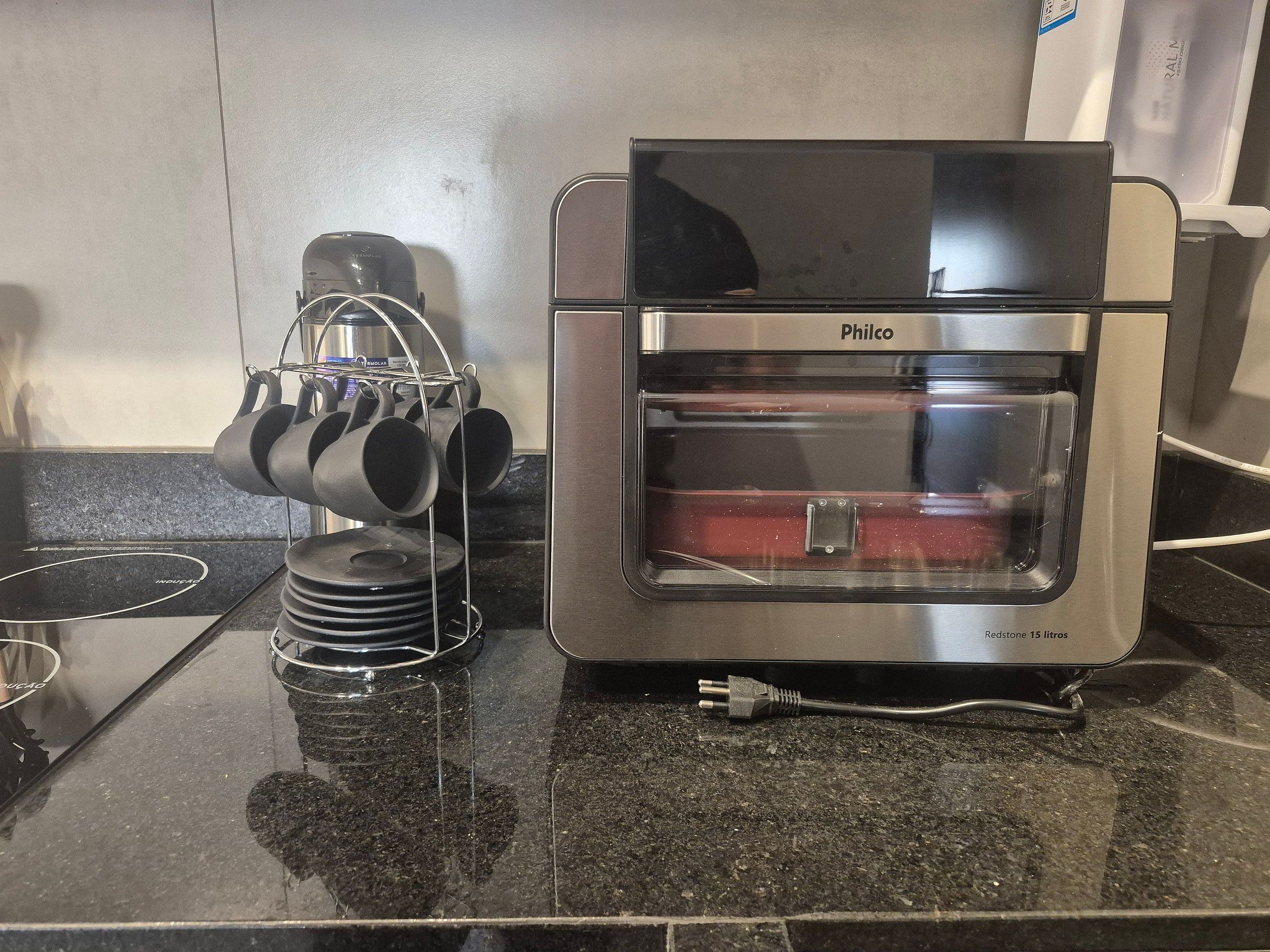 Cuina amb cafetera Philco, prestatges per a cassoles i taulell de granat.