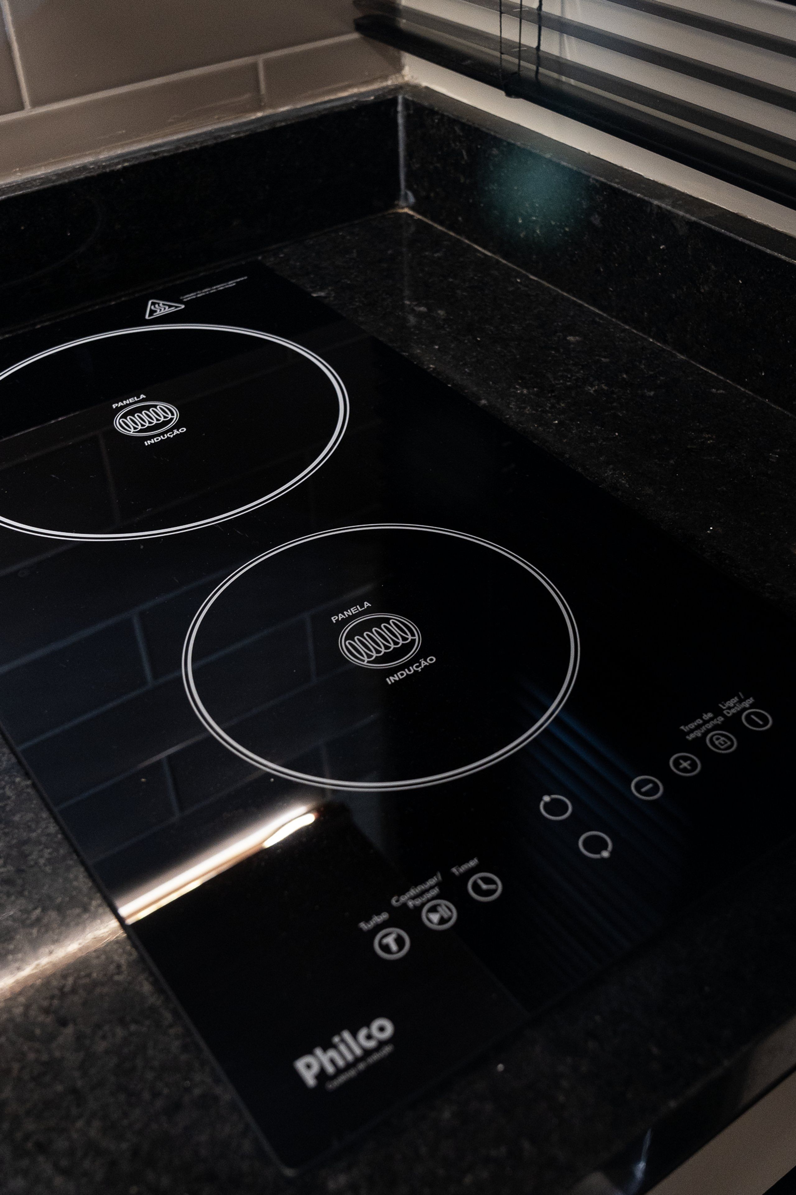 A black induction cooktop with a control panel and a digital display.