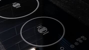 A black induction cooktop with a control panel and a digital display.