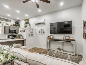 Ein modernes Wohnzimmer mit einer Couch, einem Flachbildfernseher und einem Kamin.