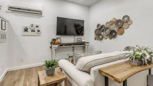 Ein modernes Wohnzimmer mit einer Couch, einem Couchtisch, einem Fernseher und Wandbildern.
