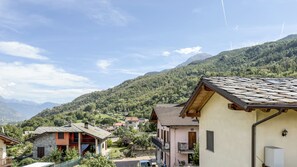 A residential area with houses, a mountain backdrop, and a clear sky. - Abri Douillet (Saint-Marcel)