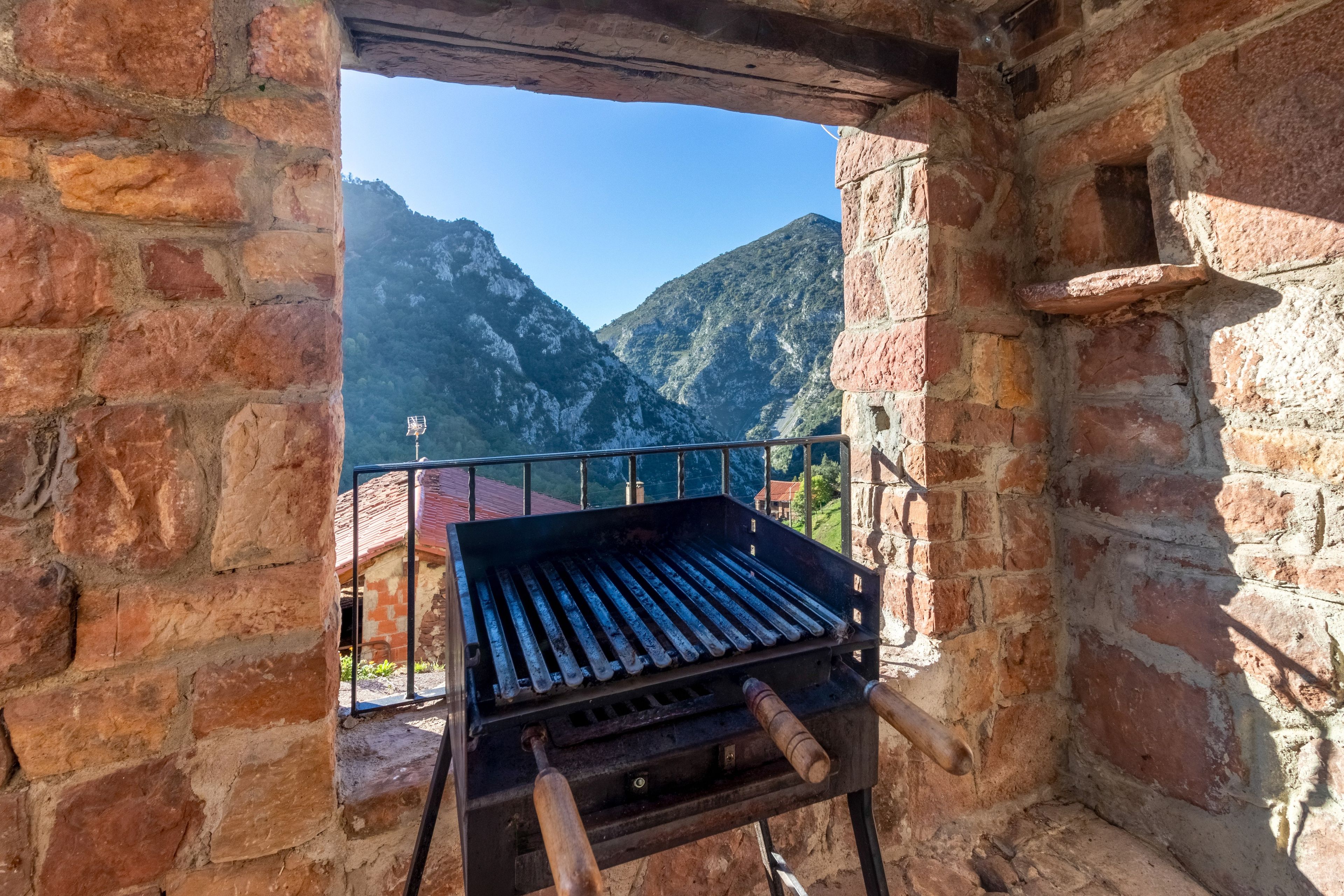 Un área de parrilla rústica al aire libre con vista a la montaña.