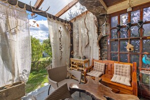 A rustic interior with a wooden bench, wicker chairs, and a table with a glass top. - Peaceful stay in the heart of a mountain village, with views of the pyrenees. (Égat)