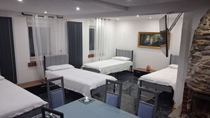 A hotel room with two single beds, a glass table, and a stone fireplace. - Forest House with Private Terrace (Sugenheim)
