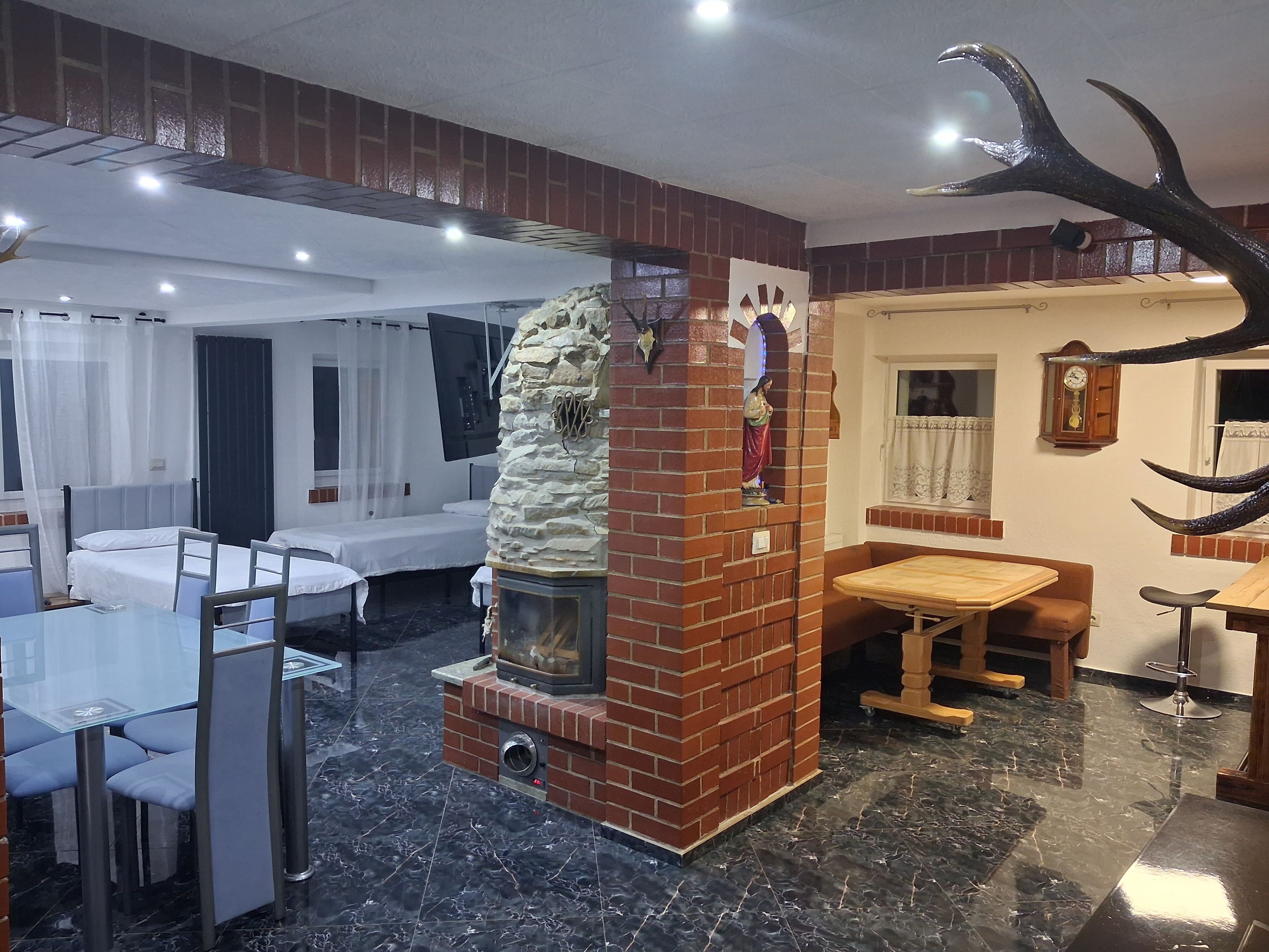 A hotel room with a fireplace, a dining area, and a bed.