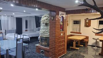 A hotel room with a fireplace, a dining area, and a bed.