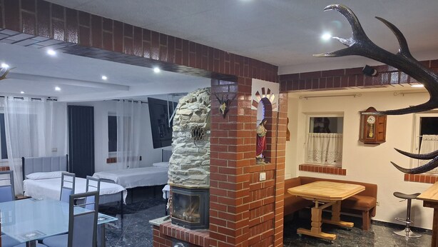 A hotel room with a fireplace, a dining area, and a bed. - Forest House with Private Terrace (Sugenheim)
