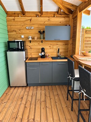 A compact kitchen with a microwave, refrigerator, and sink.