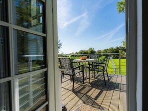 Eine Terrasse mit Gartenmöbeln, einem Tisch und Stühlen.