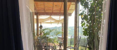 A room with a sliding glass door leading to an outdoor patio area with chairs and tables.