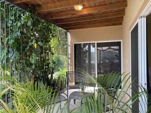 Un espacio al aire libre cubierto con una valla metálica, una silla y una mesa.