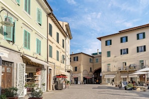 A street with buildings, a kiosk, and outdoor seating. - Room 'Camera Singola' with Wi-Fi (Grosseto)
