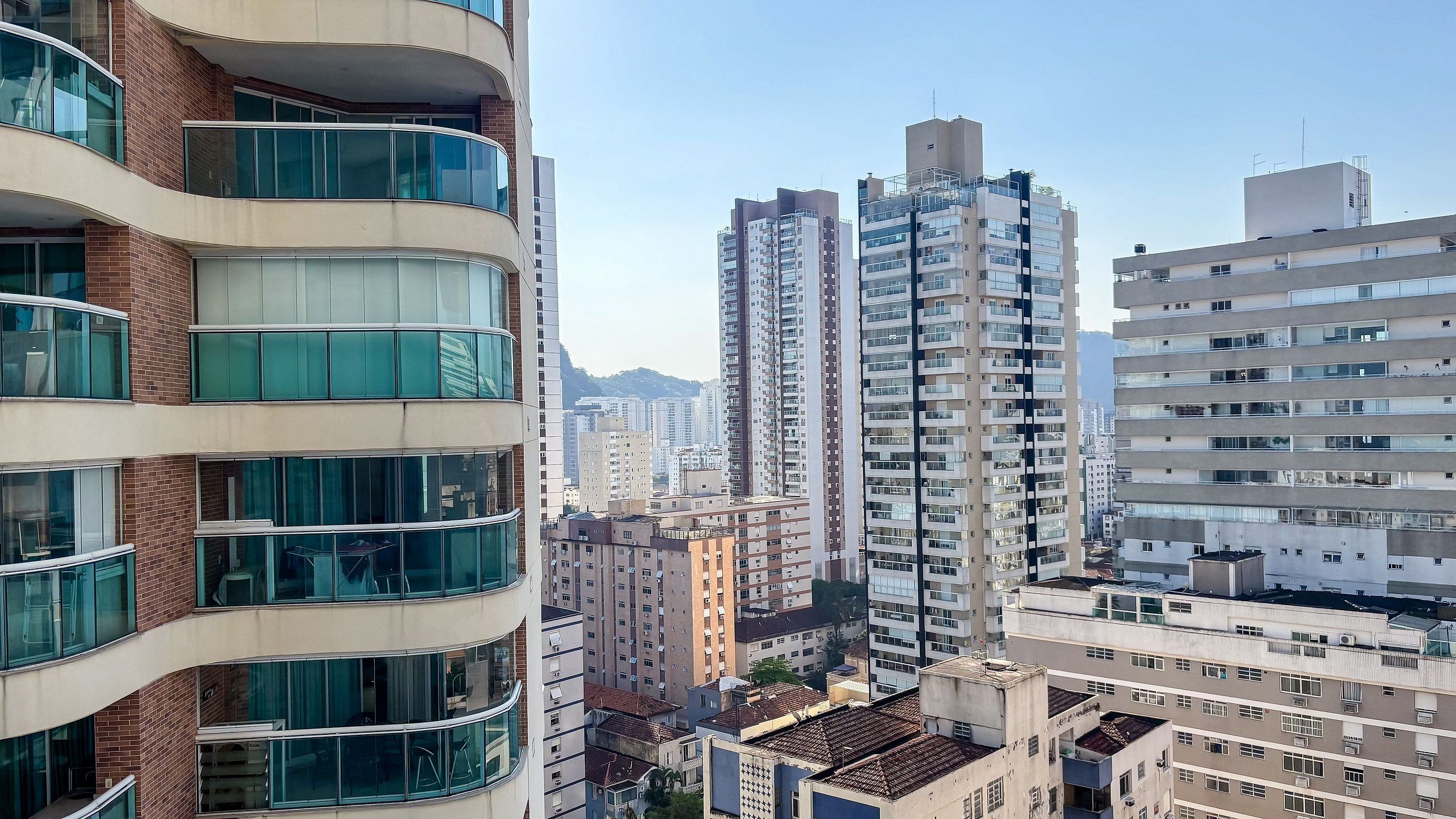 A high-rise building with multiple balconies and large windows.